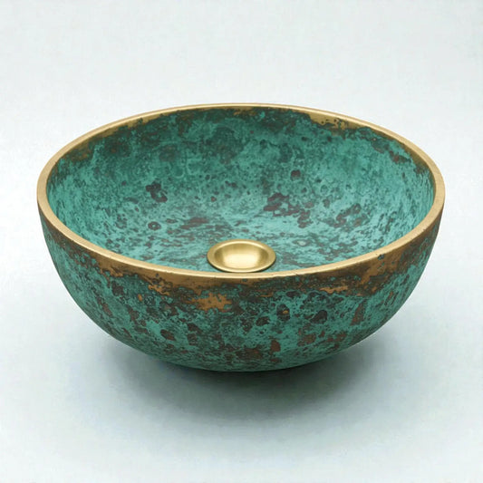 Decorative copper sink with a green and gold finish on a white background