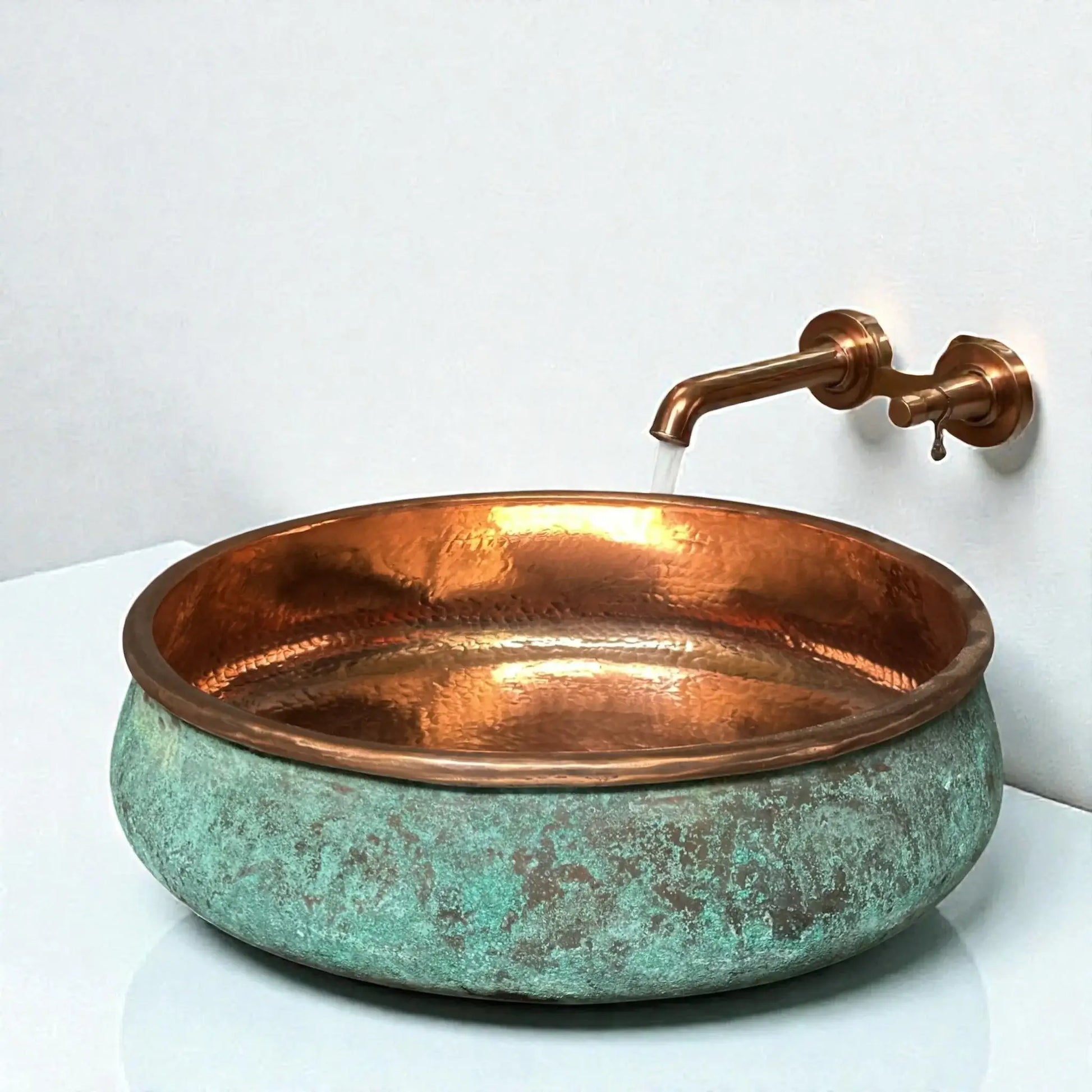 Green Patina Copper Vessel Sink with a polished copper rim and wall-mounted faucet.