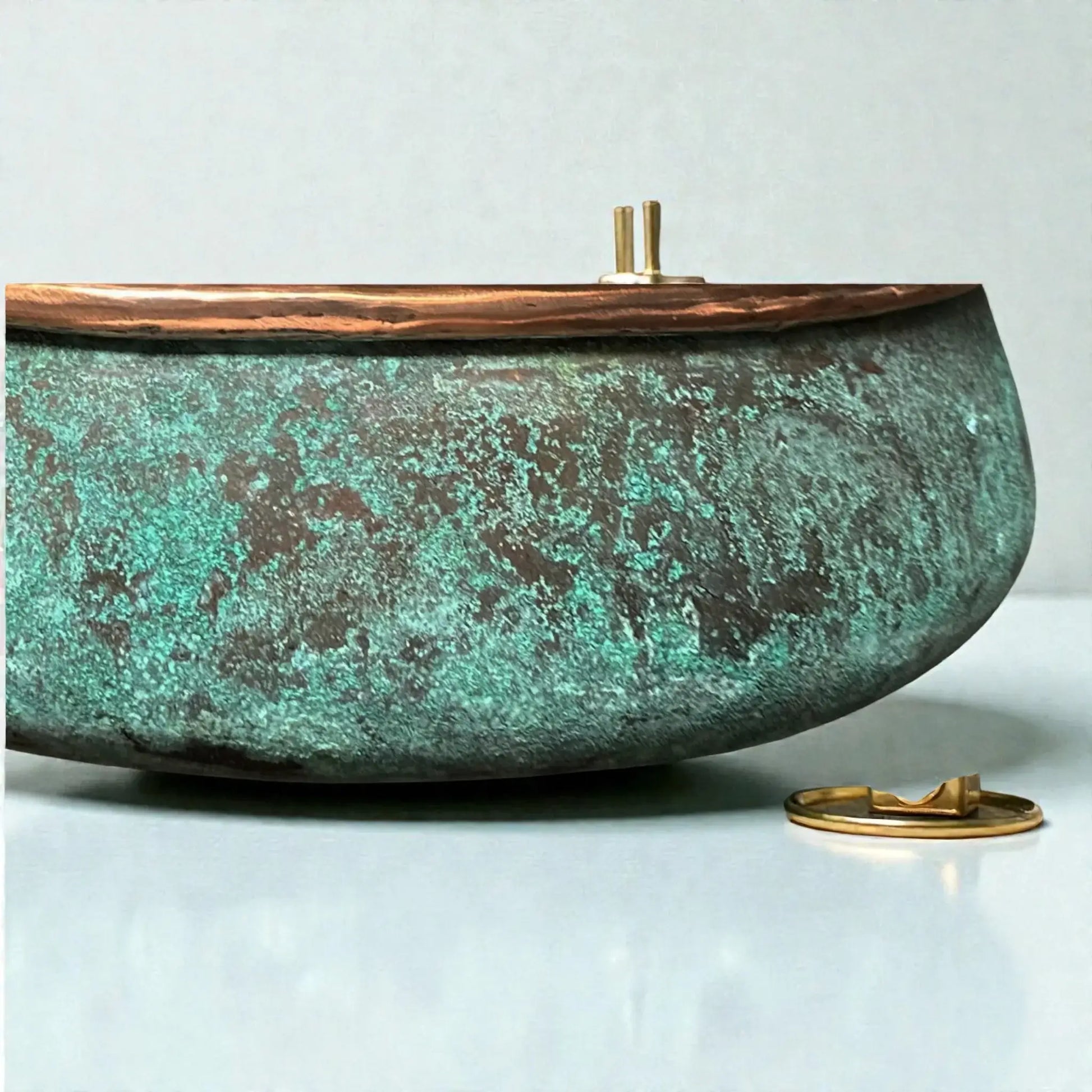 Decorative copper sink with a textured surface and gold accents on a light background