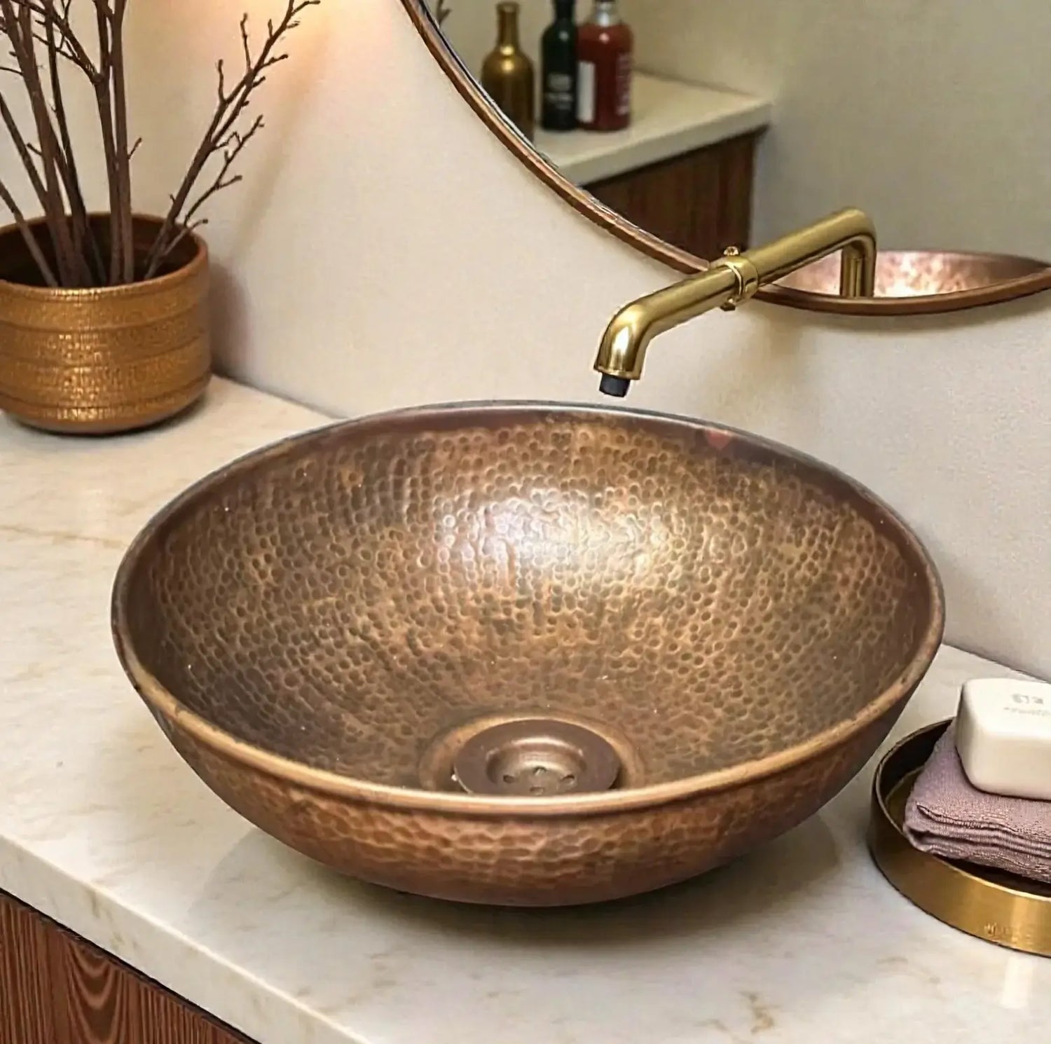 Copper sink with gold faucet on a marble countertop