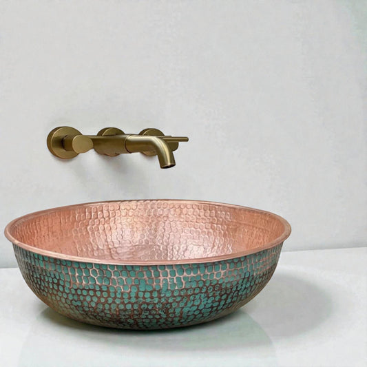 Green Patina Brass Vessel Sink displayed in a stylish bathroom with a round mirror and modern fixtures.