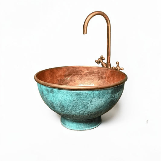 Pedestal green patina copper vessel sink displayed in a stylish bathroom with copper faucet and elegant decor.