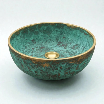 Decorative copper sink with a green and gold finish on a white background