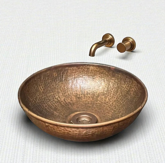Coppera Studio handmade hammered copper vessel sink with brass wall-mounted faucet.